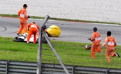 Streckenposten bergen das Motorrad des tödlich verunglückten Marco Simoncelli in Malaysia. (FOTO: DAPD)