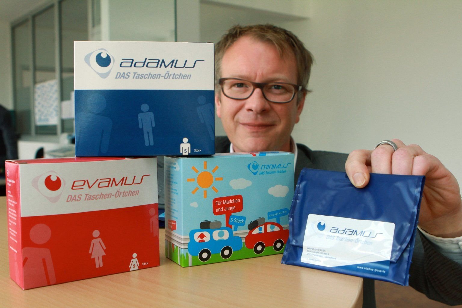 Der Geschäftsführer der adamus Group, Marc Collinet, präsentiert in Halberstadt das sogenannte Taschen-Örtchen, ein mobiles Einweg-WC. Blau ist die Ausführung für Männer, rot für Frauen und bunt für Kinder.