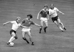 Der deutsche Stürmer Karl-Heinz Rummenigge (l) wird von Österreichs Verteidiger Heribert Weber (2.v.l.) angegriffen. Rummenigges Angriffspartner Horst Hrubesch (r, oben) wird vom österreichischen Verteidiger Josef Degeorgi (2.v.r.) bewacht. (dpa-Archivfoto vom 25.06.1982).