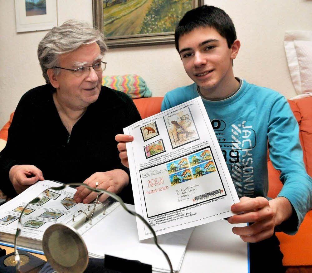 Hans-Ulrich Streuber und sein Enkel Tom blättern durch das Thematik-Exponat der Saurier.