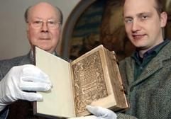Der Superintendent i.R. Albrecht Steinwachs (l.) und Restaurator Gerit Depping zeigen am Montag (25.04.2005) in der Wittenberger Stadtkirche St. Marien den «Kleinen Katechismus» des Reformators Martin Luther (1483-1546). (Foto: dpa)