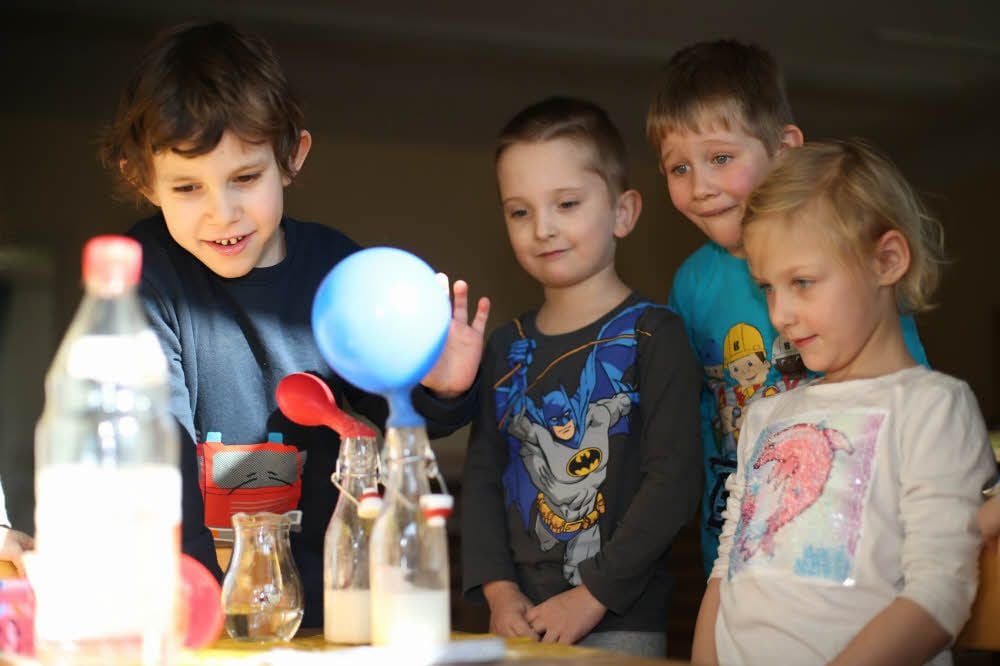 Im Montessori-Kinderhaus werden die Mädchen und Jungen zum Experimentieren angeregt: hier blasen sie mit Sprudelwasser einen Luftballon auf.