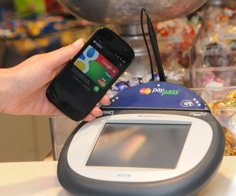 Ein Google-Smartphone wird an einer Supermarkt-Kasse neben ein so genanntes PayPass Gerät zur elektronischen Zahlungsabwicklung gehalten. (FOTO: DPA)