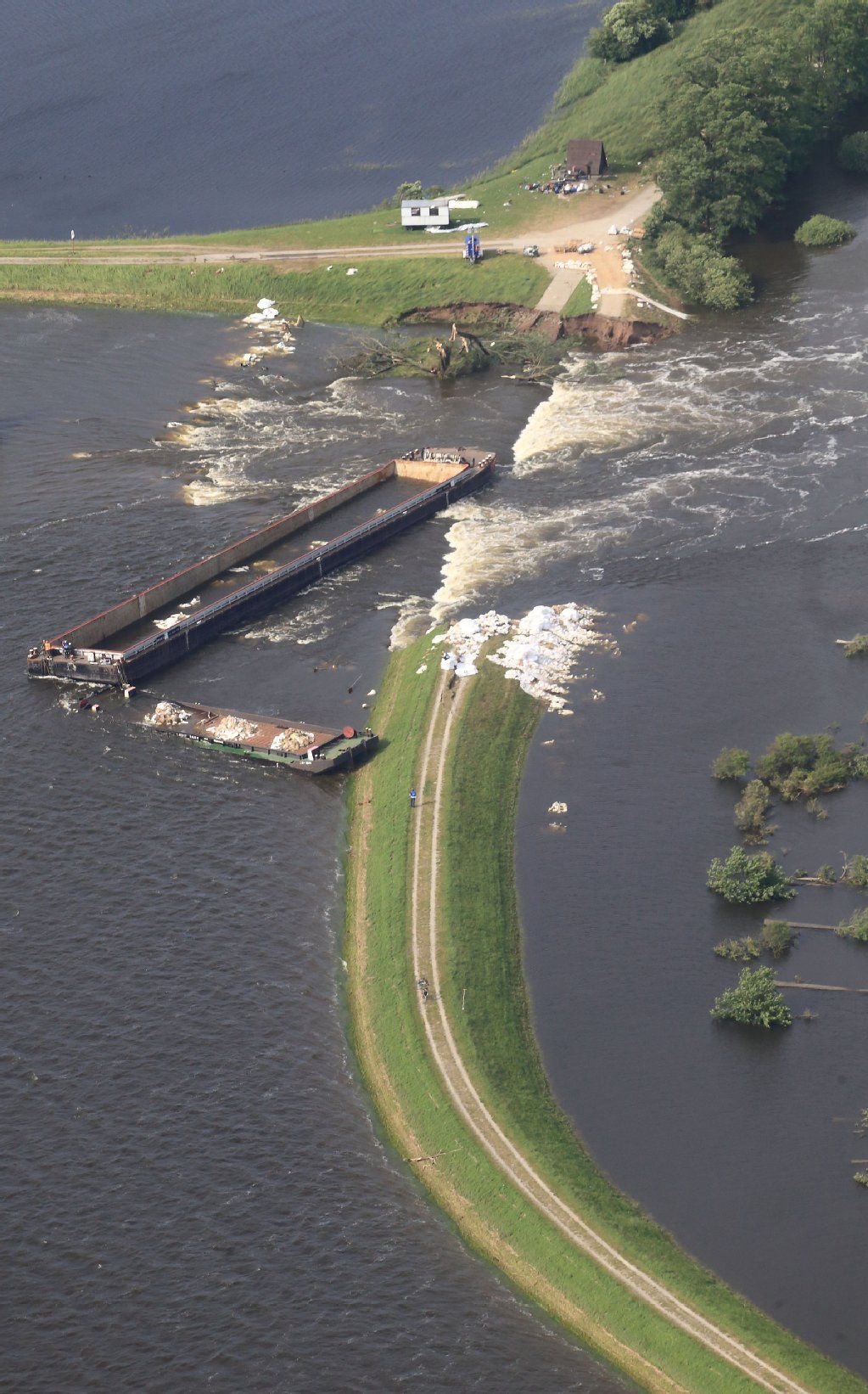 Blick auf die zwei am Samstag (15.06.2013) in den Durchfluss bei Fischbeck bugsierten und gesprengten Kähne, die die Lücke schon erfolgreich verkleinert haben