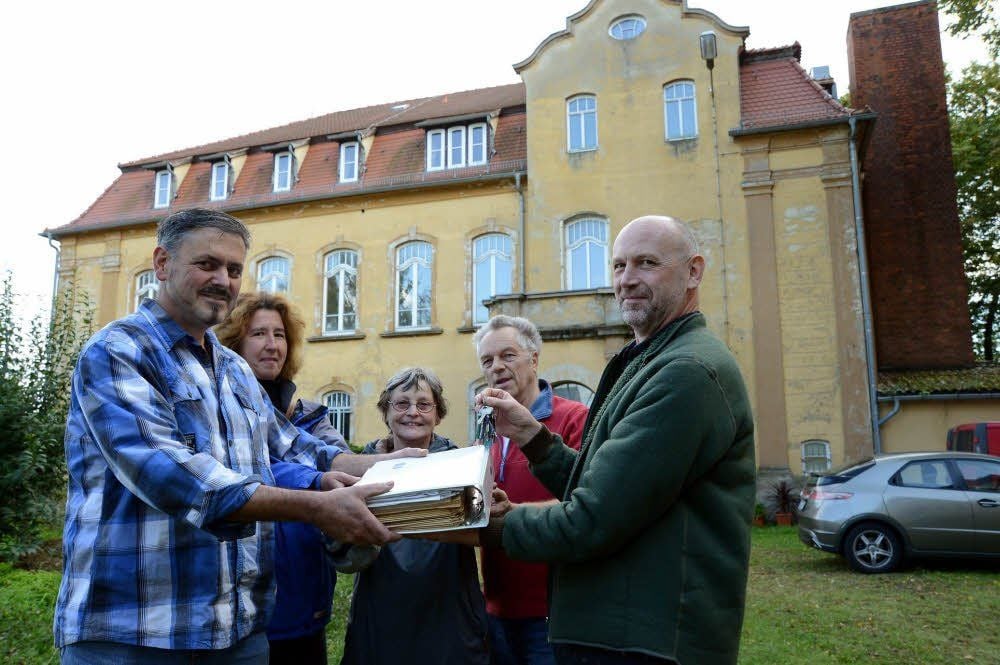 Andreas Ham (links) ist der neue Besitzer des Hauses neben der ehemaligen Schweinemastanlage in Salsitz. Er bekommt die Schlüssel und die Unterlagen von Hartmut Gröschner (rechts).