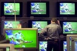 Zusehen und schweigen: Mensch vor einer Wand aus Fernseh-Geräten (Foto: dpa)