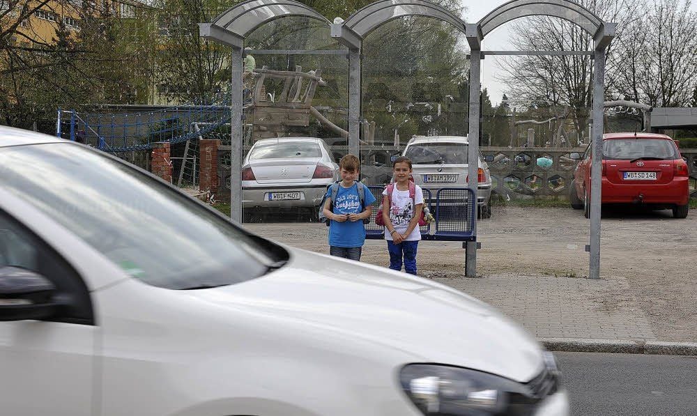 Davin und Marleen aus der zweiten Klasse warten am Bushaus, das direkt an der Torgauer Straße steht.