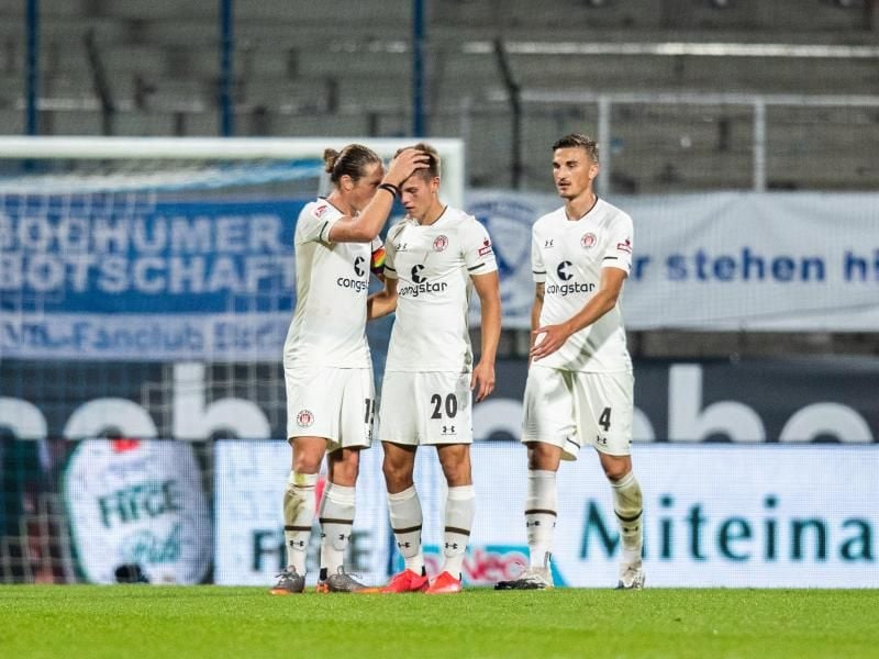 Nach dem Spielende können sich Paulis Spieler über den Punktgewinn freuen. Foto: Marcel Kusch/dpa