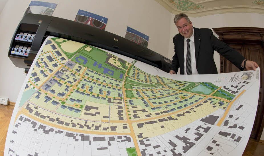 Jens Hoyer von K2-Computer an einem riesigen Plotter, mit dem er ganze Stadtviertel ausdrucken kann.