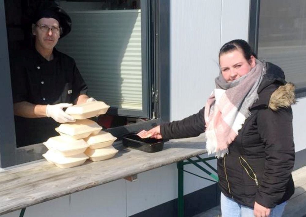 Zwei Mitarbeiter von Tankstellenpächter Christoph Pötzsch probieren die Warenschleuse aus. Jürgen Krause verkauft Essen an Daniela Tschage.