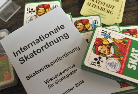 Blick auf eine Auswahl an Skatkarten mit einer Ausgabe der Internationalen Skatordnung. (FOTO: DPA)