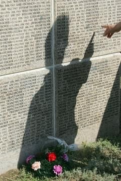 Auf einem Granitwürfel ist am Samstag (09.09.2006) auf dem deutschen Soldatenfriedhof Rossoschka bei Wolgograd der Schatten einer Person zu sehen, die versucht, einen Angehörigen zu finden. (Foto: dpa)