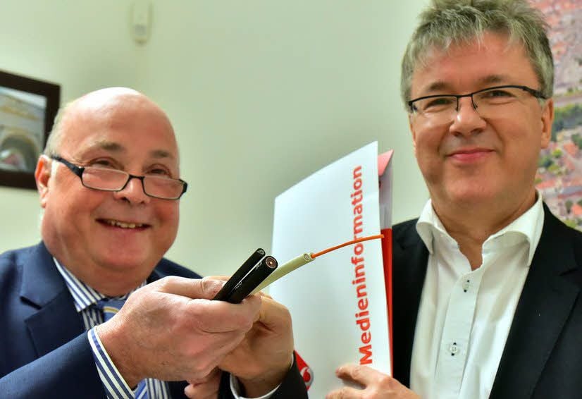 Vodafone-Betreuer Norbert Kreisel (li.) und Oberbürgermeister Robby Risch zeigen die Kabel, die das schnelle Internet möglich machen.