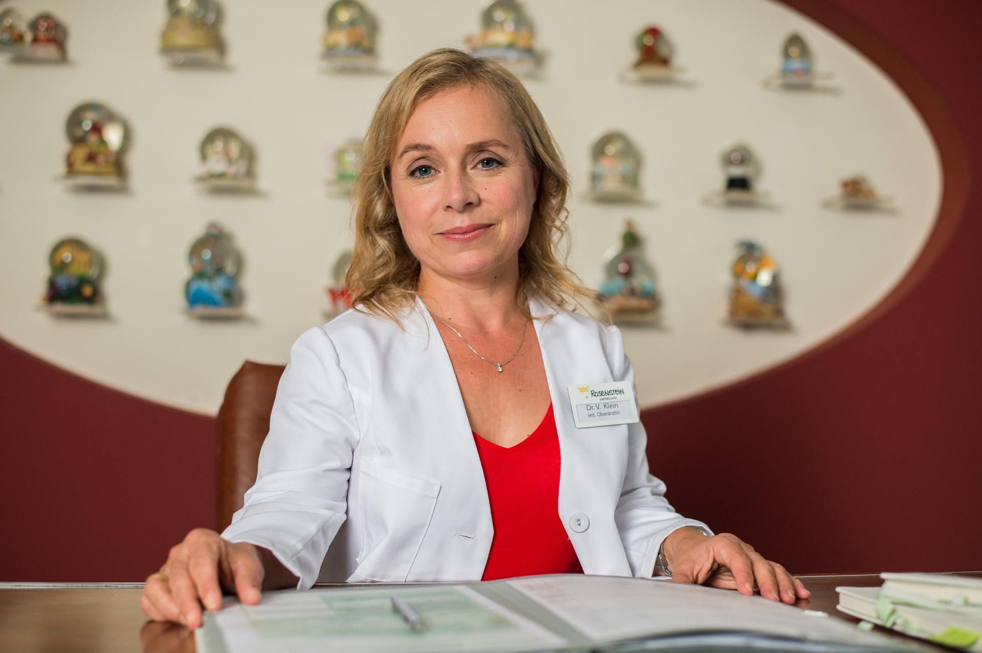 Die Schauspielerin Christine Urspruch sitzt am Set der TV-Serie „Dr. Klein“ an einem Schreibtisch.