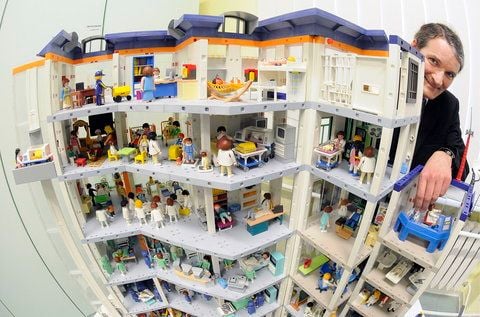 Gernot Rücker, Leiter der Rostocker Simulationsanlage für Notfallausbildung, steht neben der Spielzeugklinik mit Playmobil-Figuren. (FOTO: DAPD)