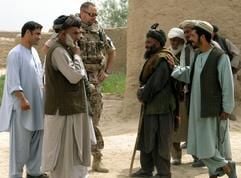 Ein Soldat des Wiederaufbauteams der Bundeswehr in Afghanistan steht in Kundus neben einer Gruppe von Afghanen. (Foto: dpa)