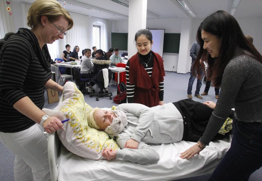 Linh Ngo (Mitte) und Linh Pham (rechts) bei einer Übung in einem Hettstedter Klassenraum der Innova-Altenpflegeschule.