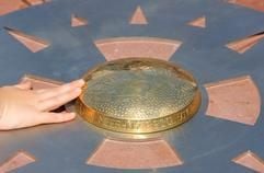Eine Kinderhand berührt in Gelnhausen-Meerholz (Main-Kinzig-Kreis) ein neues Denkmal am derzeitigen geografischen Mittelpunkt der EU. (Foto: dpa)