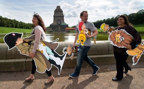 Mit den Abrafaxen in den Händen präsentieren Maren Ahrens, Sascha Wüstefeld und Flavia Scuderi (v.l.) vom «Mosaik Verlag Steinchen für Steinchen» vor dem Völkerschlachtdenkmal in Leipzig die Mosaik Geschichte «Kaiser, Krieger, Löwenjäger - Die Abrafaxe und das Völkerschlachtdenkmal». (FOTO: DPA)