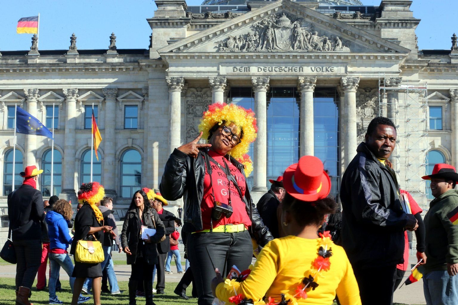 Menschen mit schwarz-rot-goldenen Perücken feierten vor dem Reichstagsgebäude in Berlin.