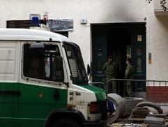 Polizisten bewachen am Dienstagmorgen (09.08.2005) in Berlin den Eingang des Hauses, das in der Nacht gebrannt hat. (Foto: dpa)