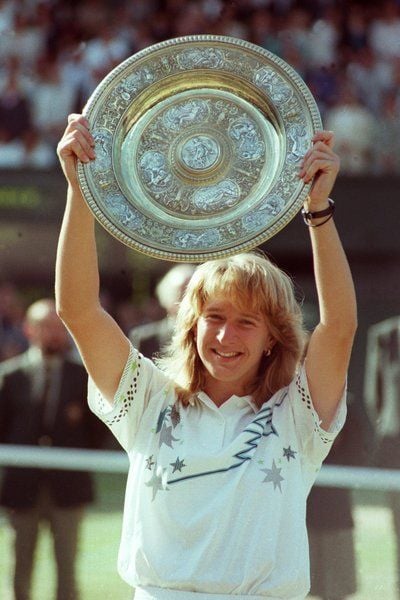 Nach ihrem ersten Sieg bei den All England Championships in Wimbledon präsentiert Steffi Graf im Juli 1988 die Silberschale den Fotografen. (FOTO: DPA)