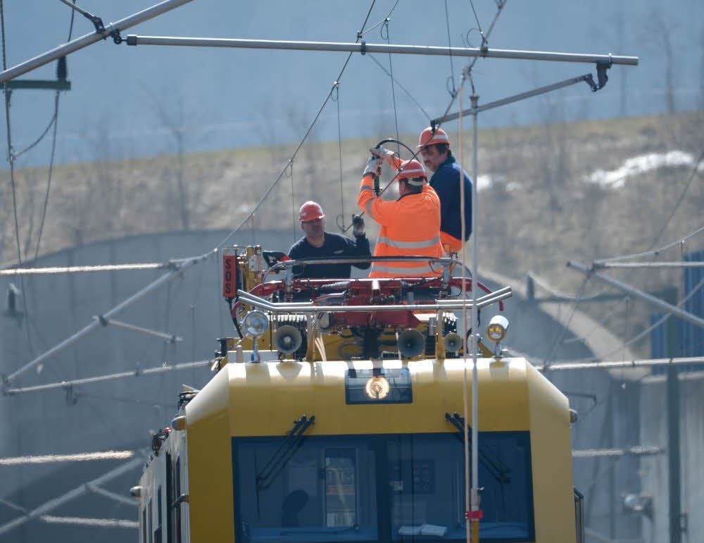 Mitarbeiter der Deutschen Bahn setzen eine Oberleitung instand.