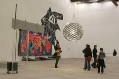 Junge Leute stehen unter der «umgekehrten Spiegellampe» des Dänen Olafur Eliasson in der Ausstellung «36x27x10» im White Cube des Palastes der Republik in Berlin. (Foto: dpa)