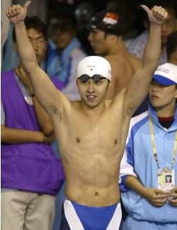 Japanese swimmer Kosuke Kitajima celebrates 02 October 2002 after winning the men's 200m breaststroke final and setting a new world record at the 14th Asian Games. Kitajima clocked a world-record time of 2.09.97 to win the gold. dpa