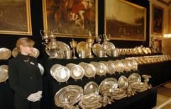 Allein 124 Teller umfasst ein Service aus Silber, das im Schloss Marienburg bei Hannover von einer Mitarbeiterin des Auktionshauses Sotherby's bewacht wird. Auch das Service soll ab Mittwoch (5. Oktober) versteigert werden. (Foto: dpa)