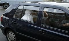 Einer der drei mutmaßlichen Täter des tödlichen Messerangriffs im Jugendheim Rodalben (Rheinland-Pfalz) wird am Sonntag (23.11.2003) von zwei Beamten in einem Zivilfahrzeug der Polizei in den Hof des Amts- und Landgerichts in Zweibrücken gefahren. (Foto: dpa)