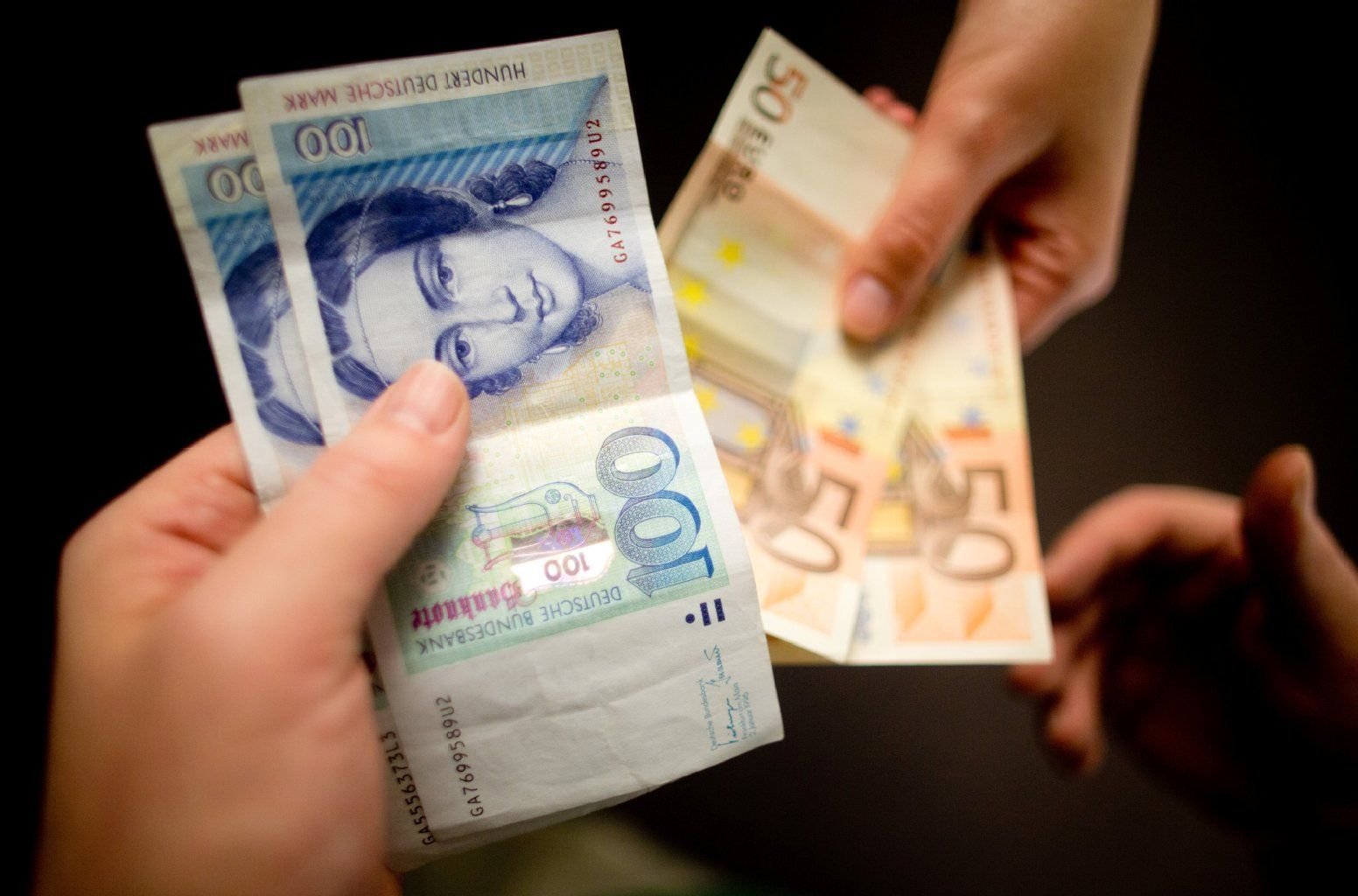D-Mark-Scheine werden gegen Euro-Scheine symbolisch getauscht.