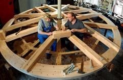 Der Mühlenbaumeister Gottfried Schumann (r) und sein Mitarbeiter Stephan Ziller arbeiten in der Werkstatt in Mulda an einem Wasserrad mit einem Durchmesser von 5,25 Metern, das für die Hintere Mühle in Deutschneudorf bestimmt ist. (Foto: dpa)