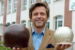 Vor Deutschlands ältester Schokoladenfabrik, der Halloren-Schokoladenfabrik GmbH in Halle (Saale), steht der Geschäftsführer des Unternehmens, Klaus Lelle, mit zwei überdimensional großen Hallorenkugeln (Archivfoto vom 03.05.2004). (Foto: dpa)