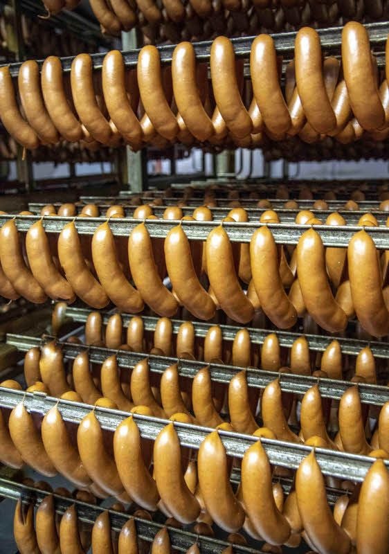 Millionen von Halberstädter Würste werden jährlich in Dosen und Gläser gefüllt. In diesem Jahr feiert die Fabrik ein Jubiläum: 135 Jahre gibt es die Konservenproduktion schon. Trotz zahlreicher Investitionen geschieht vieles noch in Handarbeit und nach traditionellen Verfahren, nicht zuletzt in der Räucherei. Dort reifen die Würste im Buchenrauch. Das ist einmalig in Deutschland.