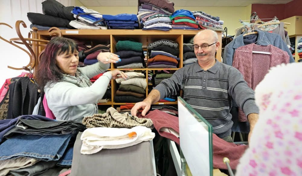 Sylke Dreßler und der Syrer Sohil Abam Assalid betreuen die Menschen, die in der Kleiderstube passende Sachen suchen.