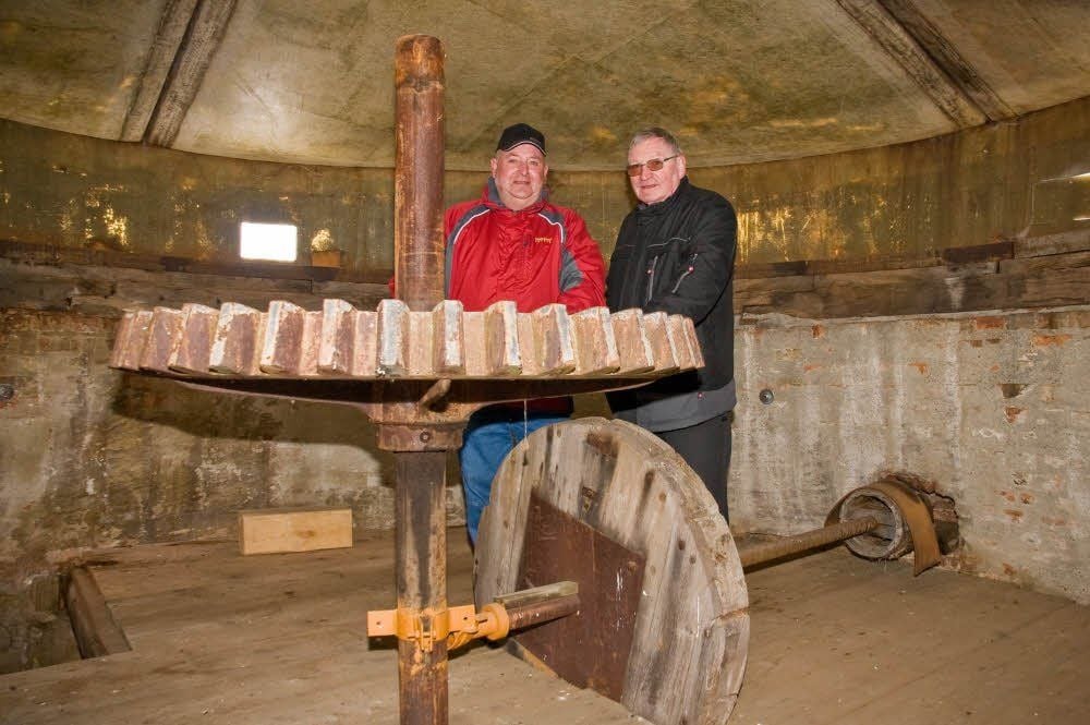 Das Zahnrad zeugt noch von der früheren Funktion der Schafstädter Mühle. Michael Kuhles und Klaus Andres (r.) wollen das Gebäude restaurieren.