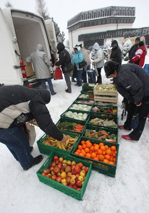 Bedürftige nehmen sich in Magdeburg an der mobilen Ausgabestelle für Lebensmittel der Magdeburger Tafel frisches Obst und Gemüse. (FOTO: DPA)