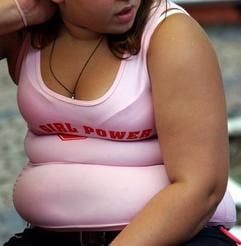 Eine übergewichtige Amerikanerin mit einem T-Shirt «Girl Power» sitzt auf einer Bank. (Archivfoto: dpa)