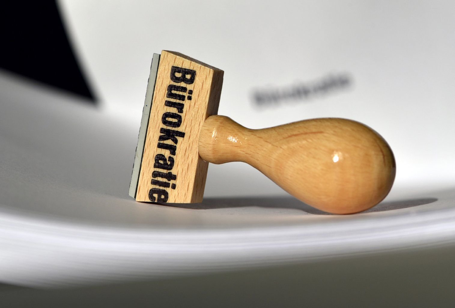Ein Stempel mit der Aufschrift "Bürokratie" liegt auf Papieren. Behördendeutsch ist oft schwer zu verstehen.