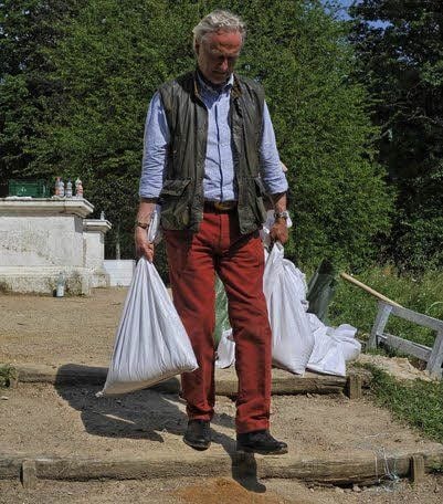 Thomas Weiss schleppt Sandsäcke.