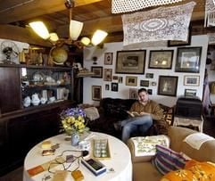 Der 22-jährige Christian Schulz sitzt in seinem Altmark-Museum in Gladigau in der Altmark in einem Wohnzimmer, wie es am Ende des vorigen Jahrhunderts auf dem Lande üblich war. (Foto: dpa)