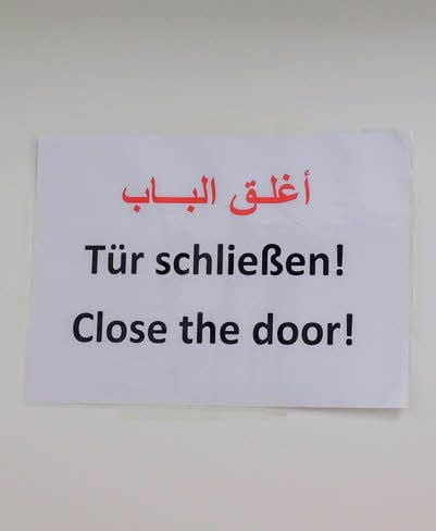 Die Mitarbeiter in der neuen Dienststelle haben es mit vielen Nationalitäten zu tun. Da ist ein dreisprachiges Schild noch das Mindeste.