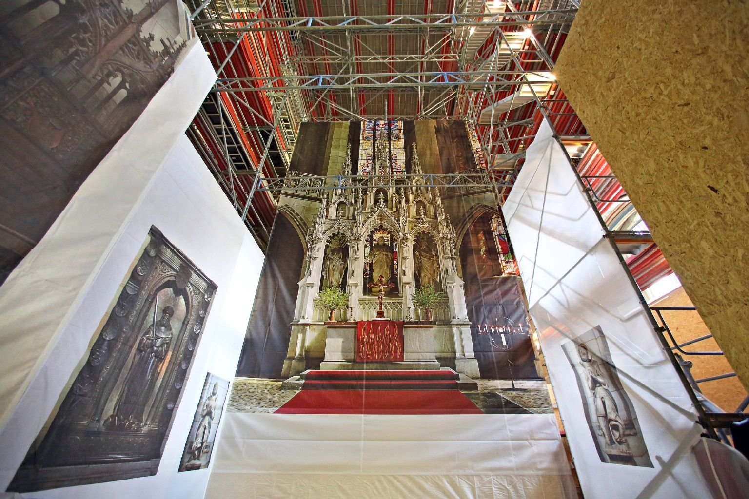 Besucher nehmen an einer Führung durch die von Baugerüsten eingehauste Schlosskirche in Lutherstadt Wittenberg teil.