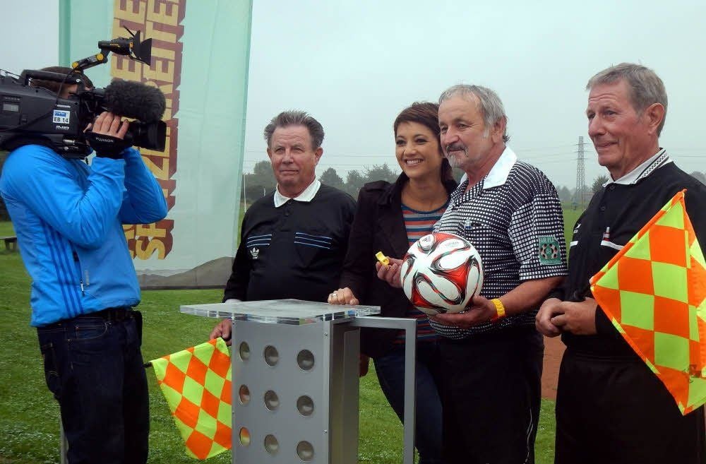 Madeleine Wehle mit dem ältesten Schiedsrichtertrio Deutschlands: Horst Kups (r.), Martin Busch (2.v.r.) und Manfred Lange (2.v.l.). Das Trio der Droyßiger SG stand für die Sendung "Außenseiter, Spitzenreiter" vor der Kamera in Theißen beim Kreisligaspiel Theißen:Heuckewalde