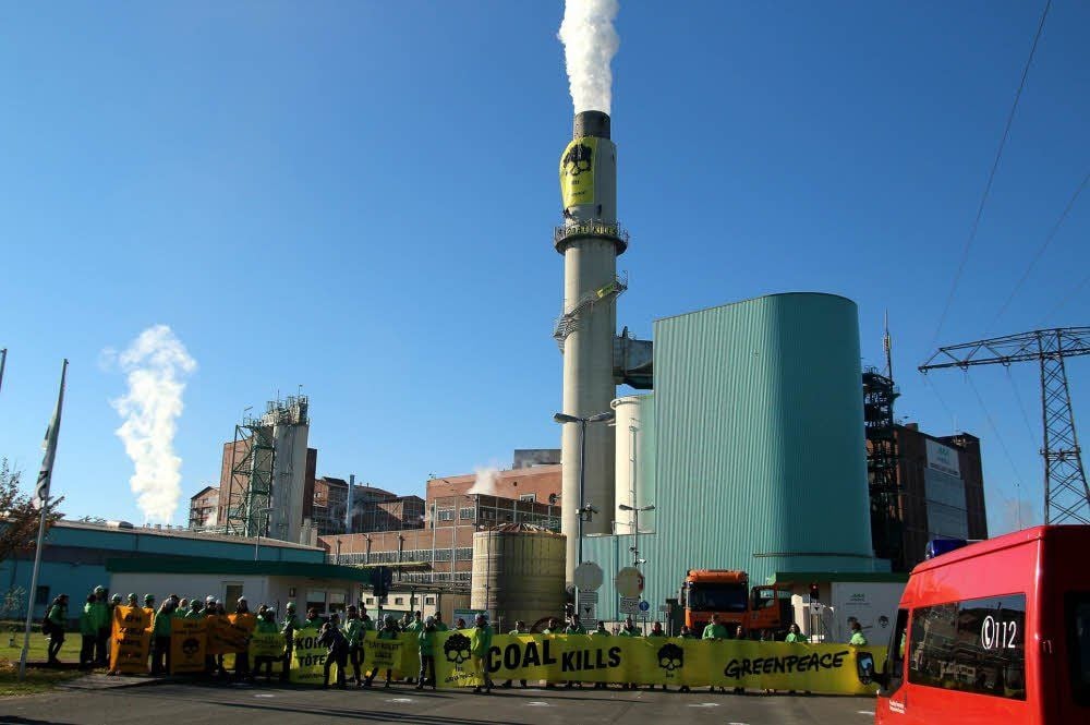 Einhundert Greenpeace-Aktivisten protestieren vor dem Kraftwerk und auch auf der Esse. Sie fordern eine Abschaltung des Werkes bis 2020.