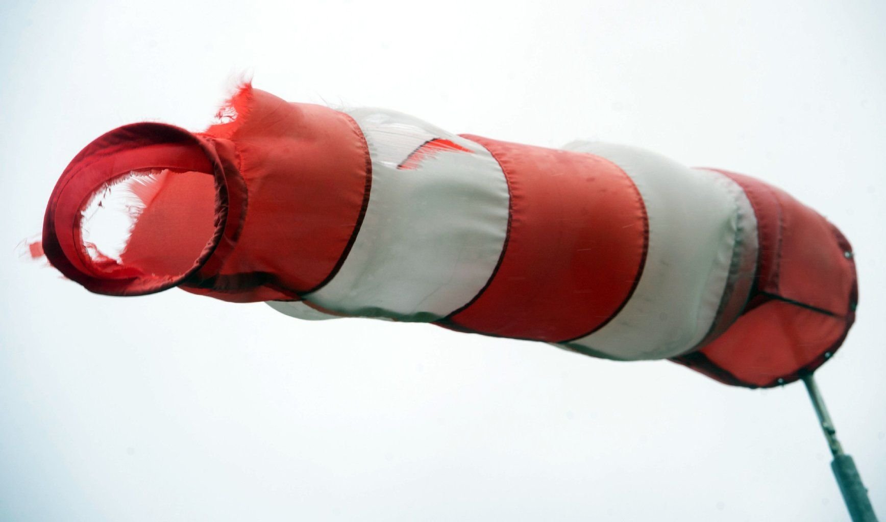 Ein Windsack steht fast horizontal in der Luft und zeigt recht starken Wind an.