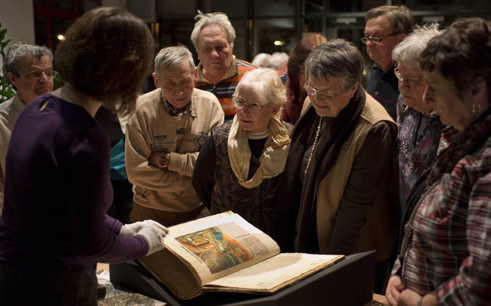Gleimhaus-Besucher bestaunen die Halberstädter Bibel, die ihnen von Bibliothekarin Annegret Loose gezeigt wird.