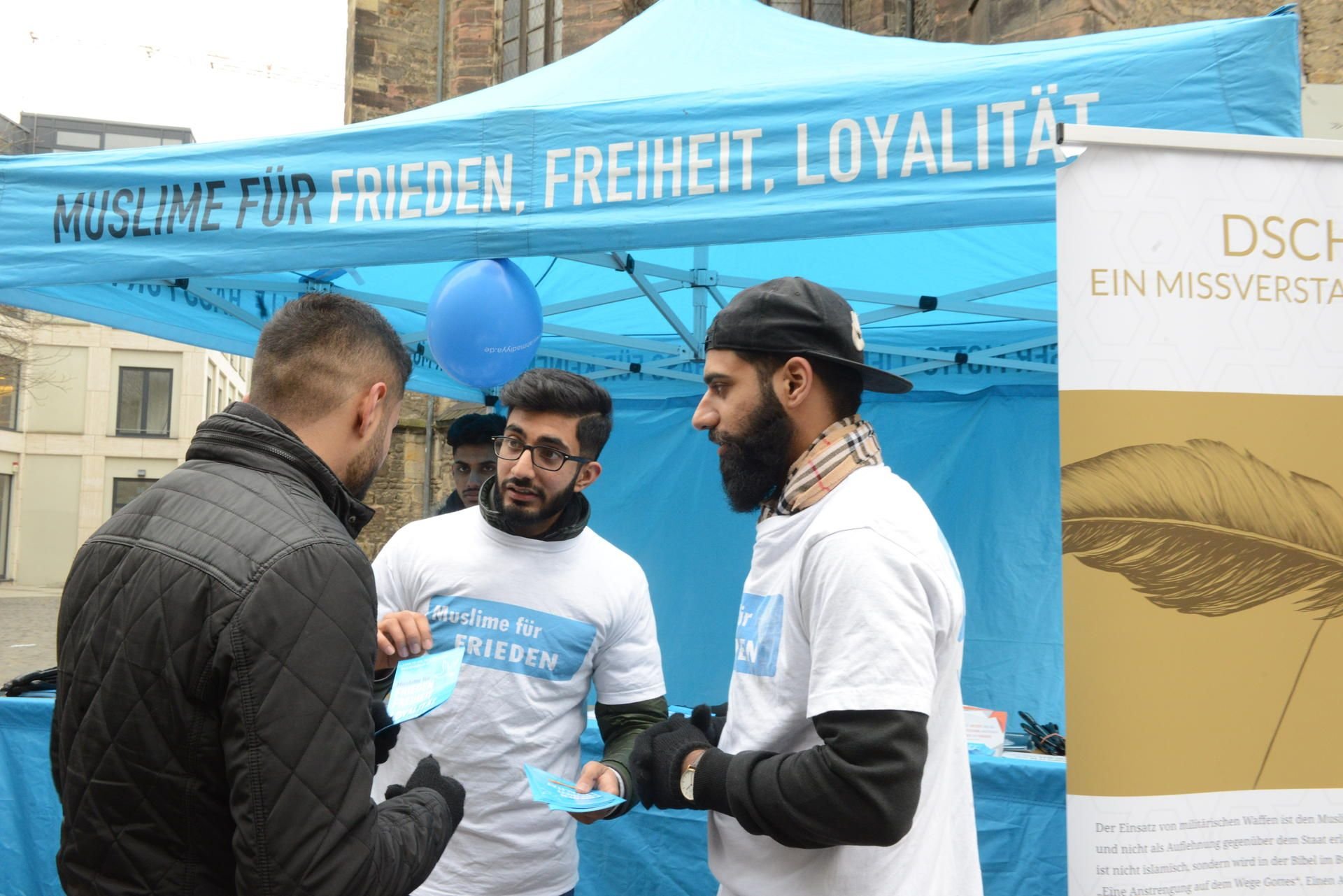 Shehroz Sial (r.) und seine Mitstreiter von der Jugendorganisation der Ahmadiyya Muslim-Gemeinschaft am Infostand an der Ulrichskirche.