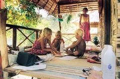 Auf der Terasse ihrer Bambushütte auf der thailändischen Insel Koh Lipe schaut Mutter Anglika (hinten) ihren Kindern Elisabeth (l) und Jonah (r) beim Spielen mit Nachbarkind Ilka zu. (Foto: dpa)
